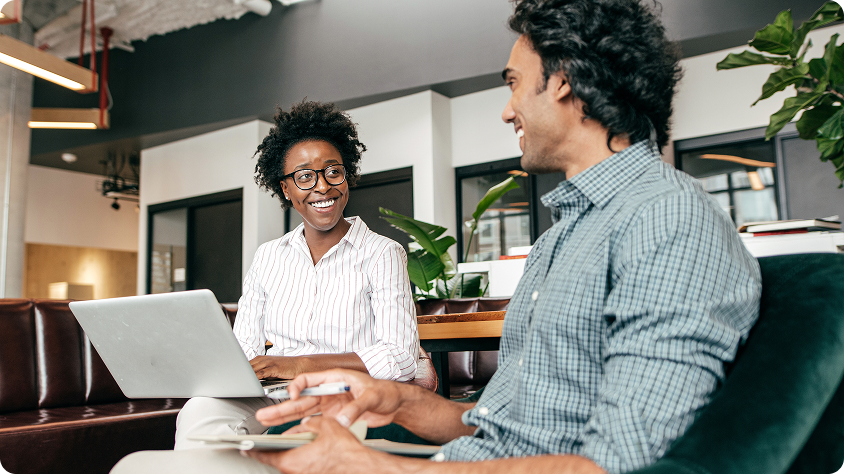 Two entrepreneurs relax in a casual office and discuss strategy